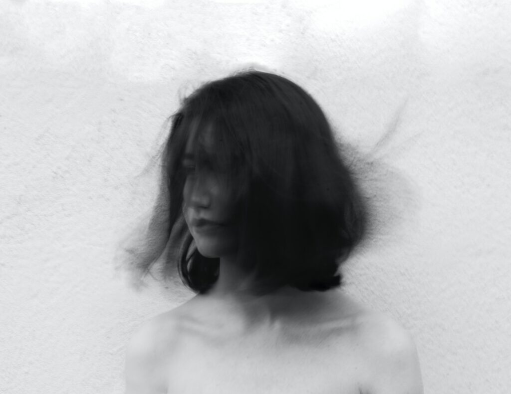 grayscale photography of woman flipping her hair